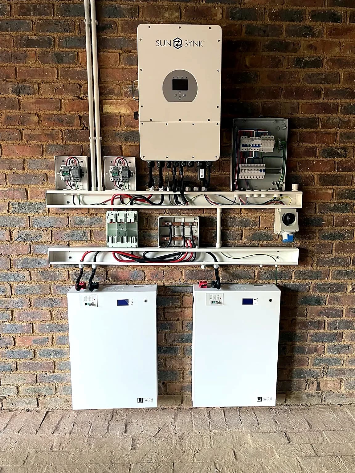 Sunsynk hybrid inverter with two wall-mounted lithium batteries installed at a home