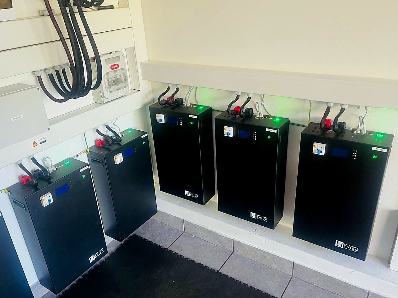 Industrial-scale lithium battery bank installed along a plant room wall