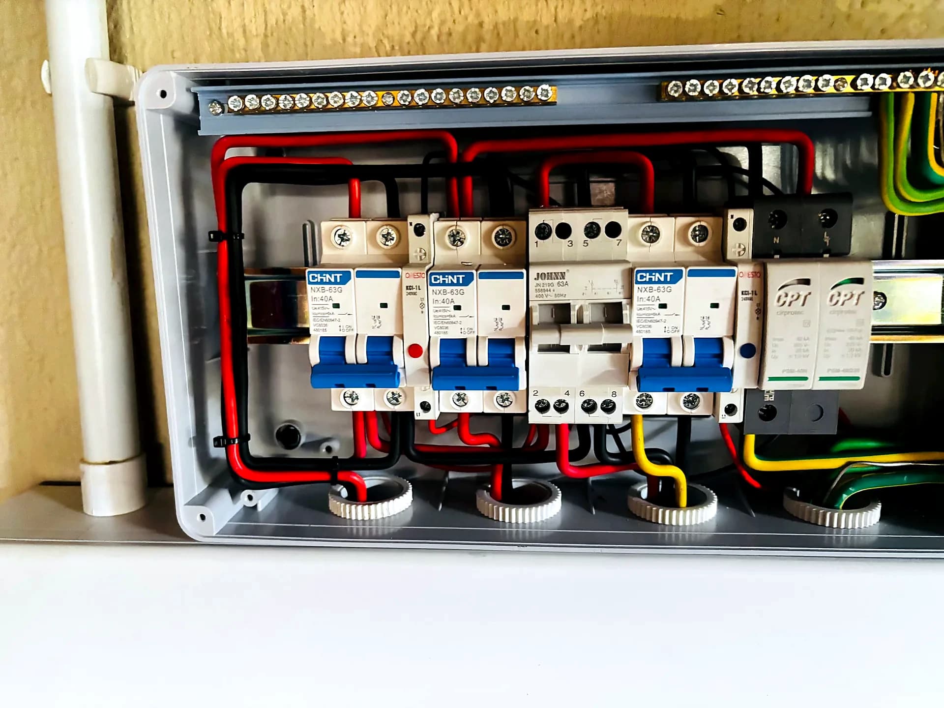 Protection and control wiring inside an enclosure, with breakers and colour-coded conductors